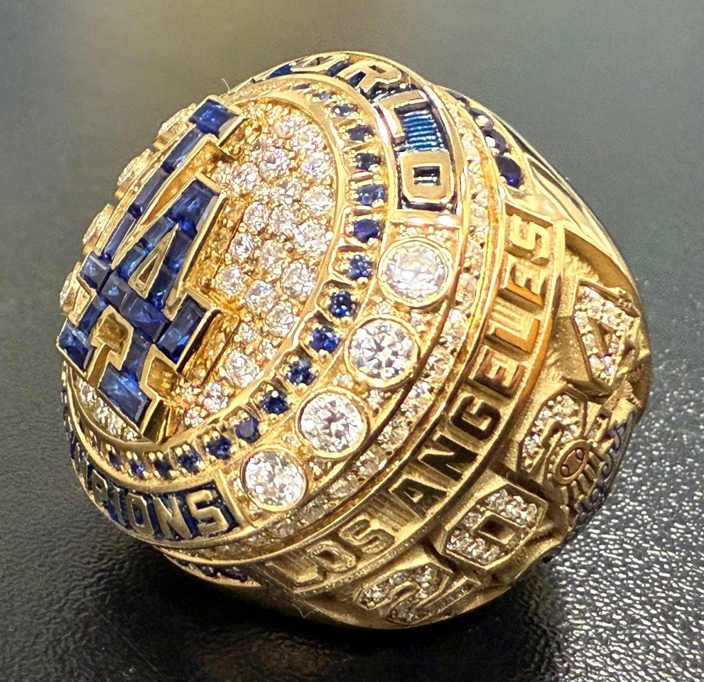 Expertly crafted in 14-karat yellow gold, diamonds and genuine sapphires, team historian Mark Langill says the Los Angeles Dodgers’ 2024 World Series Ring honors the team’s historic season and 8th title in franchise history through artistic storytelling and impeccable detail.