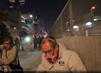 Screenshot of video provided by Lexis-Olivier Ray | A TV news crew from Univision runs from an advancing line of federal officers shooting pepper balls at protestors and press