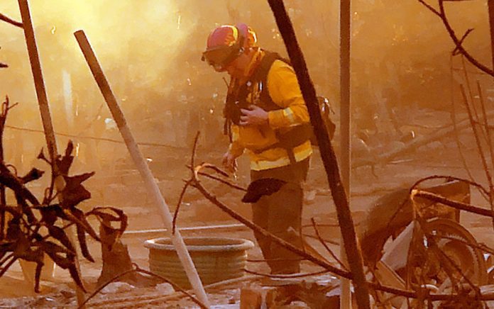 Fire aftermath in Altadena. Eaton Fire Palisades Fires. Firefighter inspecting through catastrophic loss of homes and businesses