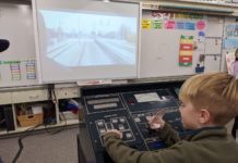 Arroyo Vista Elementary South Pasadena: AV STEM Night 2025 A young student sits at a Metro train control training board with a simulated view of the 'A line'