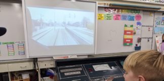 Arroyo Vista Elementary South Pasadena: AV STEM Night 2025 A young student sits at a Metro train control training board with a simulated view of the 'A line'