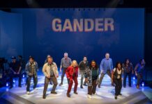 COME FROM AWAY soars on joy, hope and the kindness of strangers at A Noise Within Diverse cast dancing on a stage beneath a blue backdrop that reads GANDER.