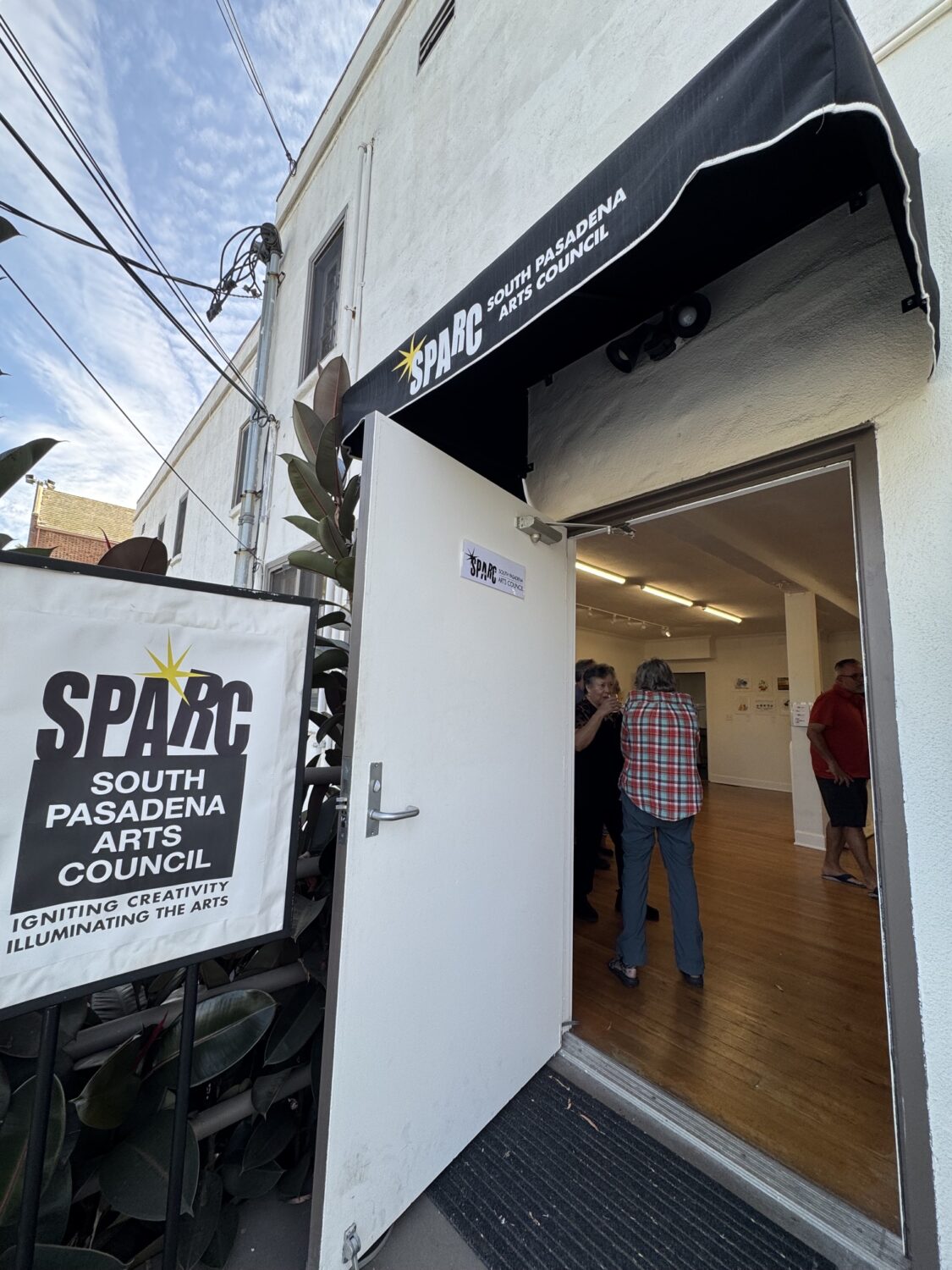 south-pasadena-news-07-12-2026-the-creative-life-blooms-senior-watercolorists 7 | The South Pasadenan | South Pasadena News Entrance to SPARC South Pasadena Arts Council with a black awning; open door showing people inside talking.