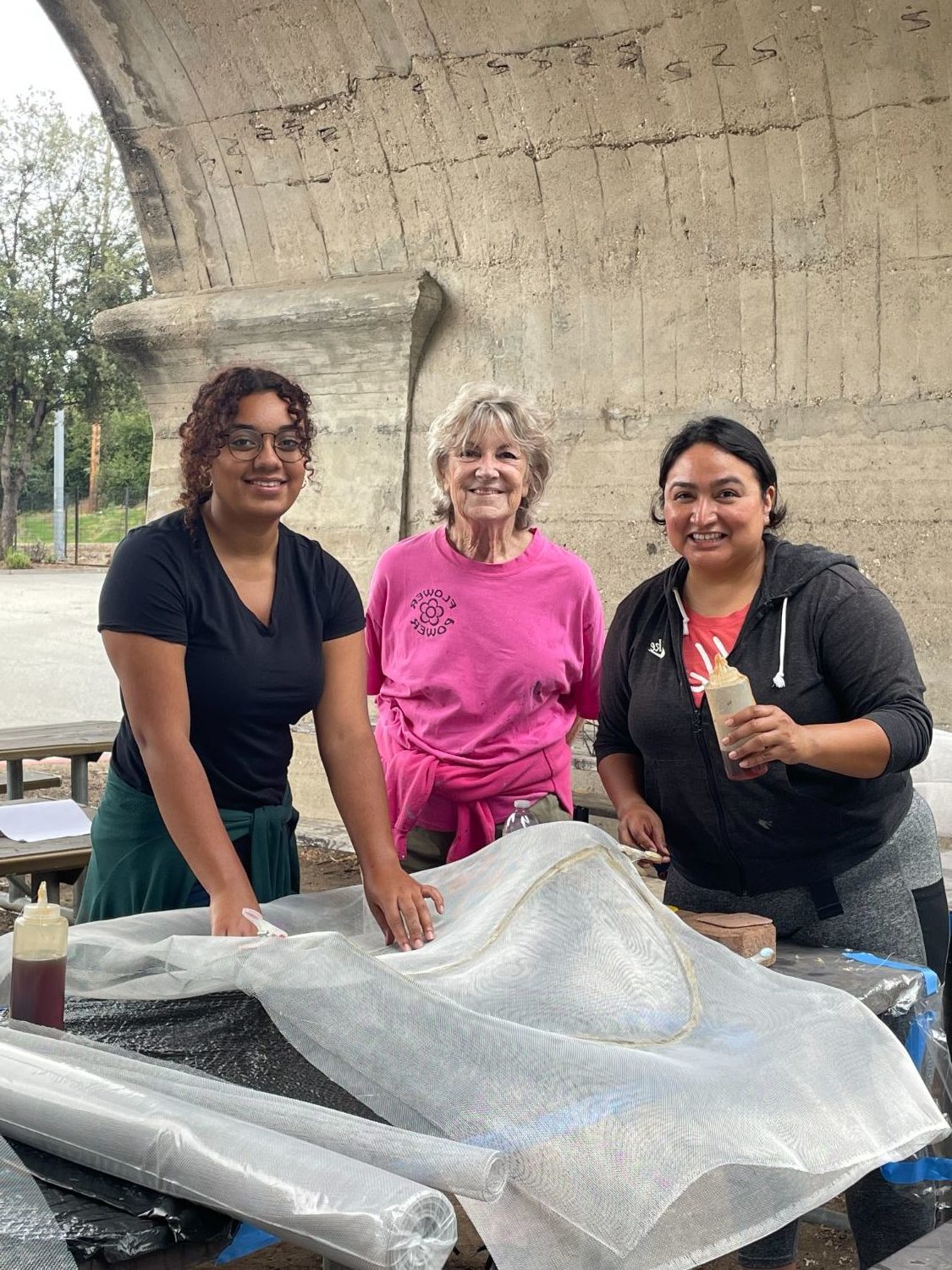 | The South Pasadenan | South Pasadena News PHOTO: Sally Kilby | The South Pasadenan | Volunteers “screen” a sculpted metal flower, covering it with a window-screen-like material. This is the first layer in creating a feature that will appear on the 2024 South Pasadena float, “Boogie Fever.” L-R are Victoria Rea; Sharon Mitchell, volunteer assistant; and Alexandra Strong.
