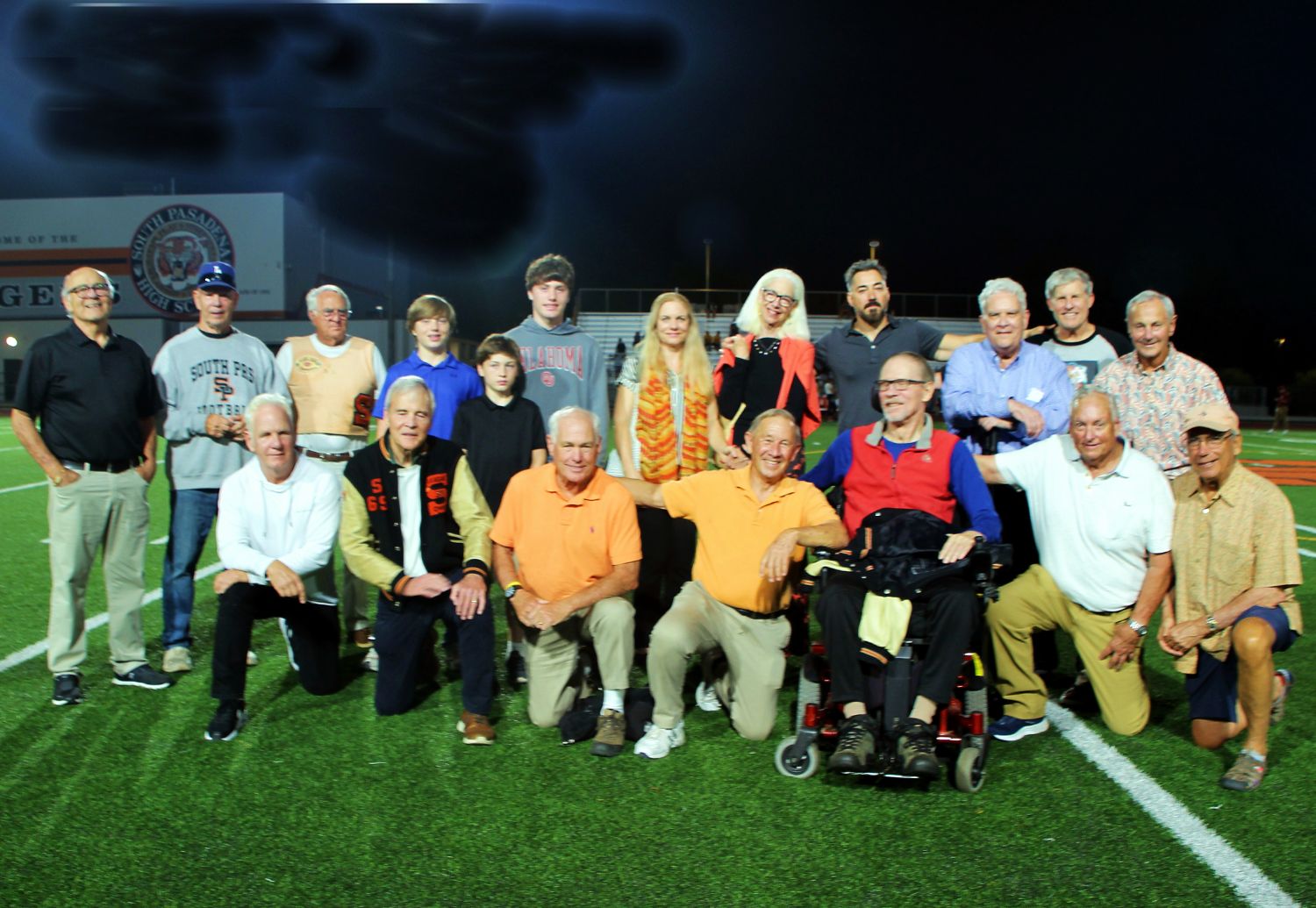 PHOTO: Henk Friezer | The South Pasadenan | SPHS football alumni join the family of Ray Solari in honoring him at SPHS Homecoming 2023: (partial list) Front row (L-R) includes Tom Davidson ‘69, Alan Vlacich ‘67, John Stellar ‘67, Pete Warner ‘63, Aiden Moran, John Cogan ‘65, Bob Howe ‘65, Joe Karlowitsch ’74 (standing), Thom MacFarlane ’75 (standing) Back row (L-R): Mike Thurman ’75, Jack Schultz ’67, Paul DeJoseph ‘69, Connie Solari ’65, Antonia Solari Moran, Christopher Solari, Harrison Moran, Arthur Moran, John Genova ‘63, Terry Kiser ‘65.