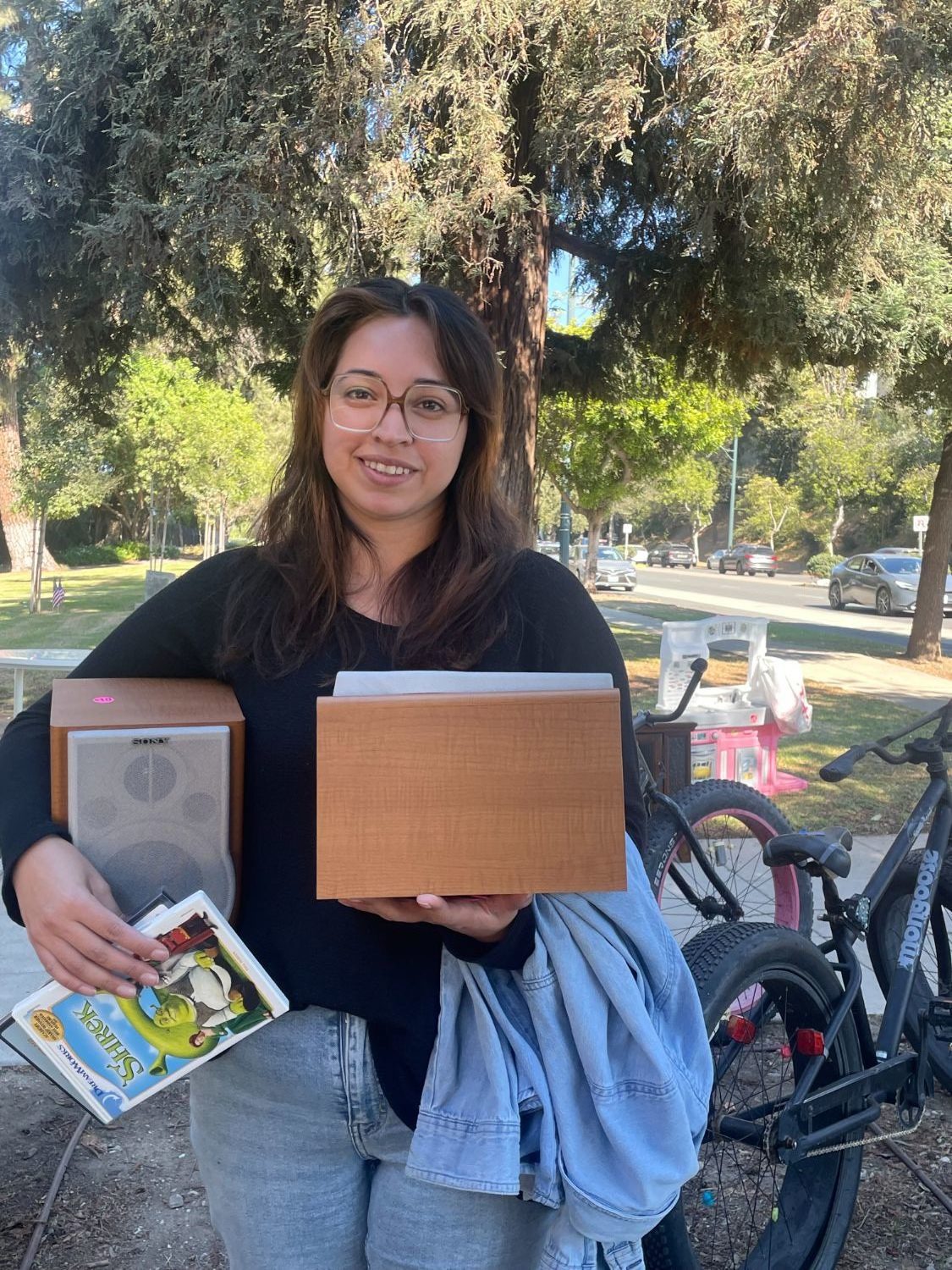 Magaly Garibaldo of Baldwin Park leaves the War Memorial Building after making purchases, including a Shrek DVD. Sale items were displayed inside and outside the building.