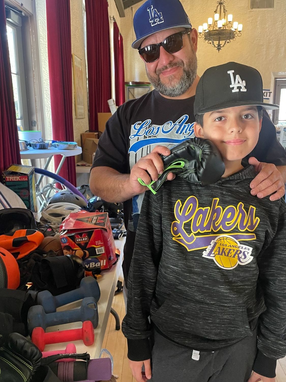 PHOTO: provided by SPTOR | South Pasadenan News | Miguel Moreno (left) demonstrates a boxing glove in the sports equipment section with Little Mickee Moreno.